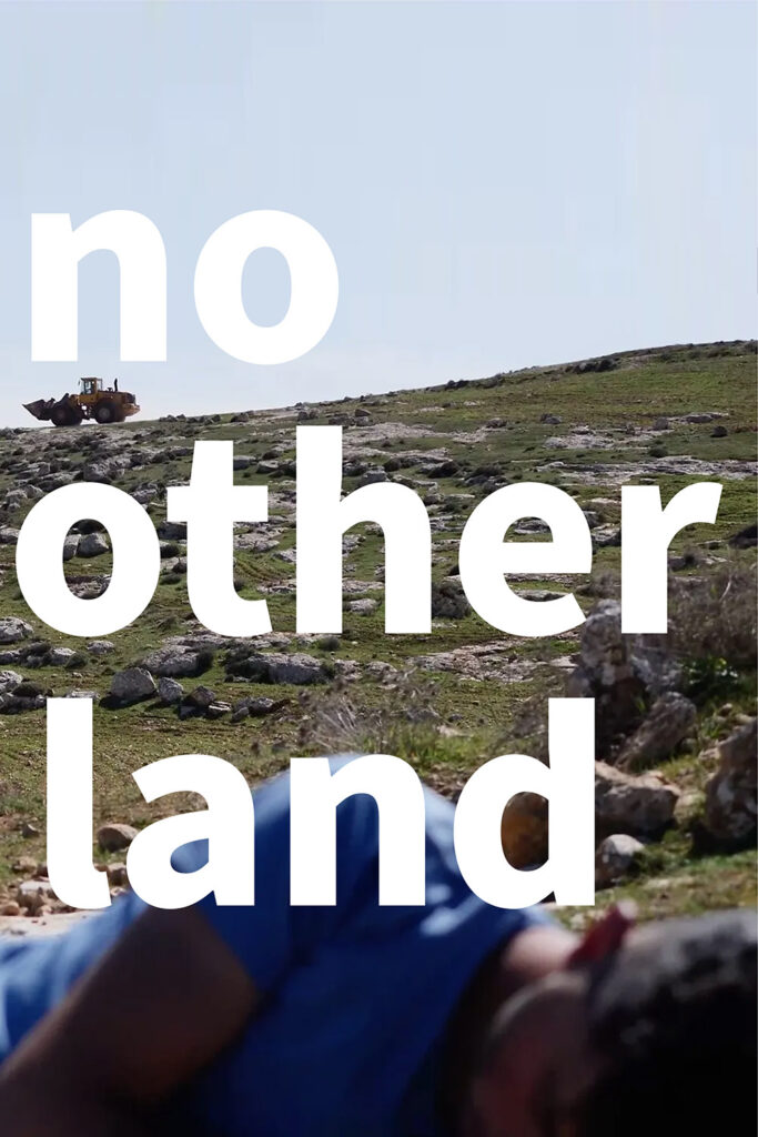 A partially visible man, out of focus, is laying in the foreground. Behind him is a hill covered with short grass and rocks. A bulldozer sits on the top edge of the hill in the distance. The sky above is a very pale blue.

Large words reading "no other land" written in white lowercase letters are written on top of the image. 